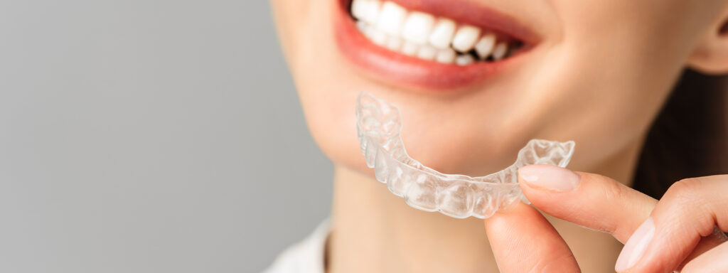 Woman smiling while wearing Invisalign clear aligners